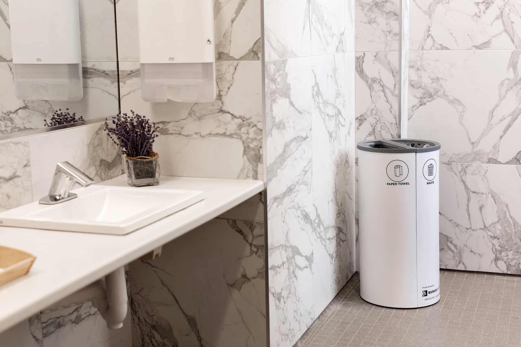 waste container labeled to collect paper towel and waste in a bathroom